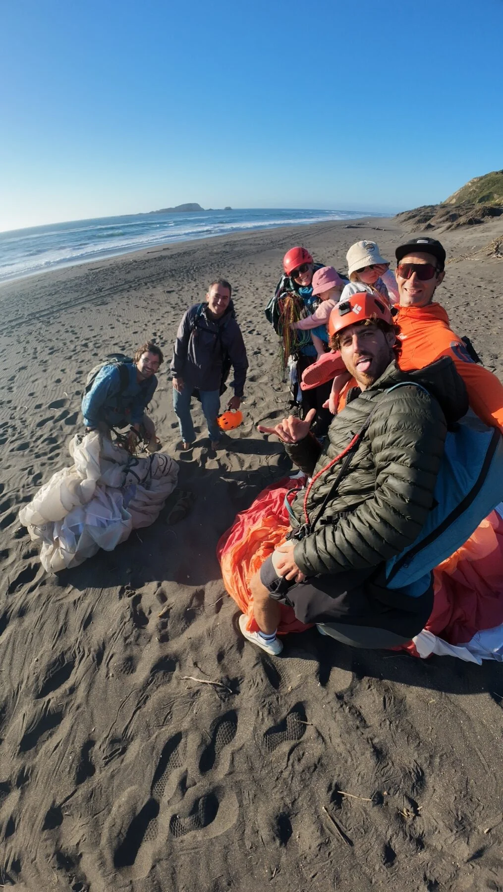 Grupo de pilotos Para Vida en la playa preparando equipos de parakite junto al mar